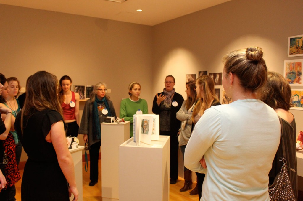 Professors Leah Niederstadt and Claudia Fieo talk to the group in the Weil Gallery