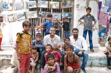 Karl Rivera ’16 and residents of Ramji Ni Chaaloi enjoy a photo exhibit featuring their community.