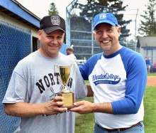 President Dennis Hanno (right) hands over the softball trophy to Norton Police Chief Brian Clark on July 14.