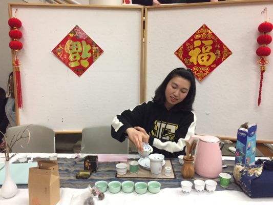 Student preparing and making tea at a table.