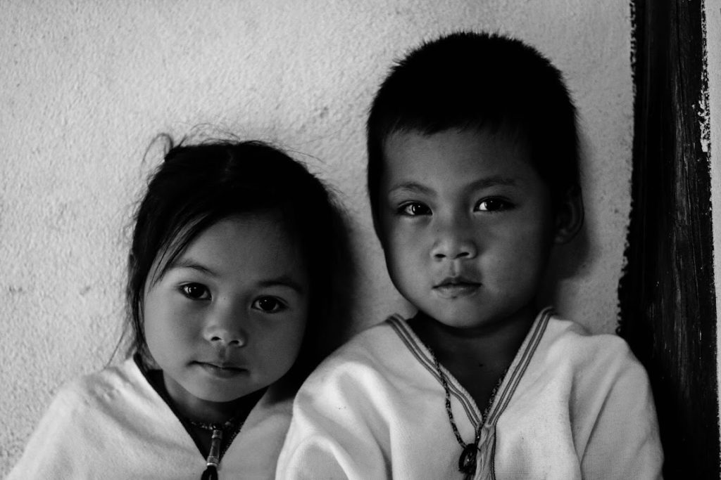 A black and white photo of two children staring at the camera