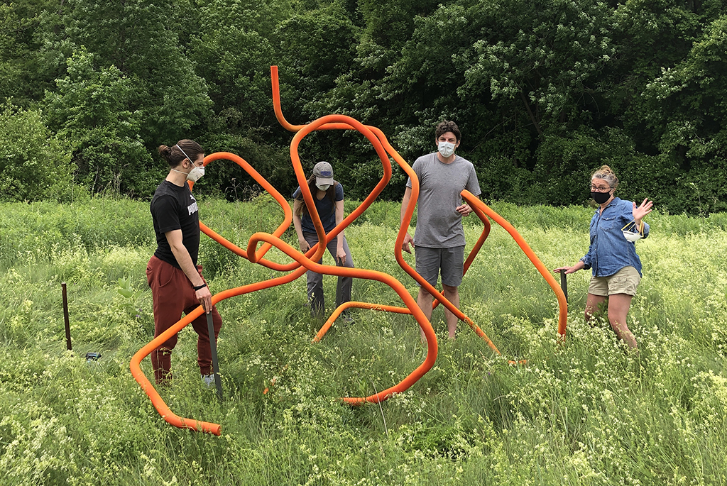 Professor Kelly Goff and group install sculpture on nature trail