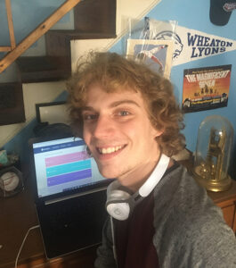 Photo of Harrison Zeiberg in front of the computer with headphones