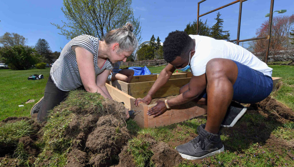 Director Elizabeth Hoy works with Helder Prece '22 to build the foundation for the garden