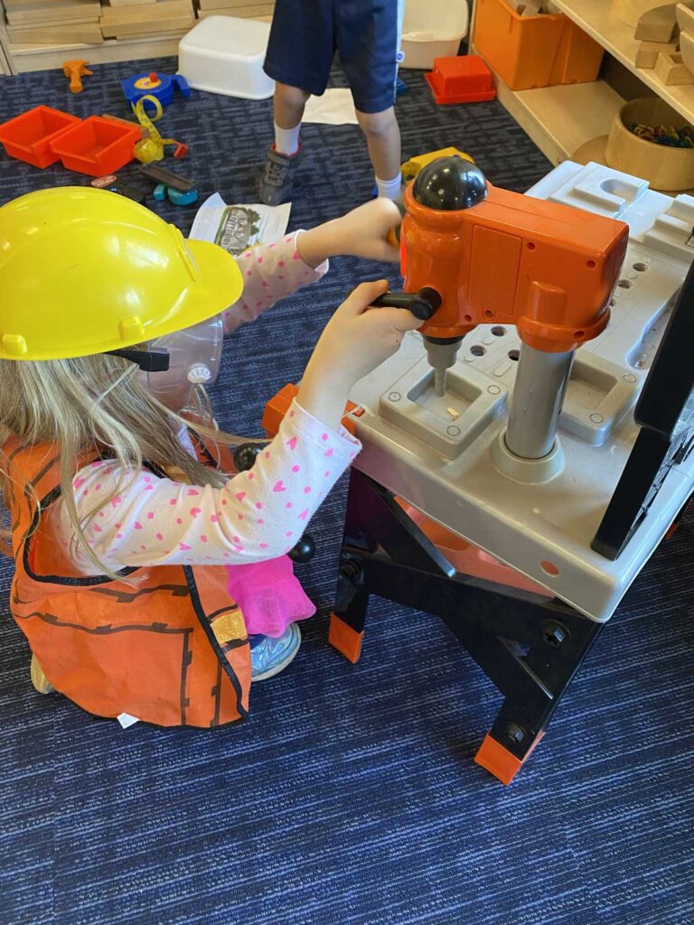 Child playing with toy construction equipment