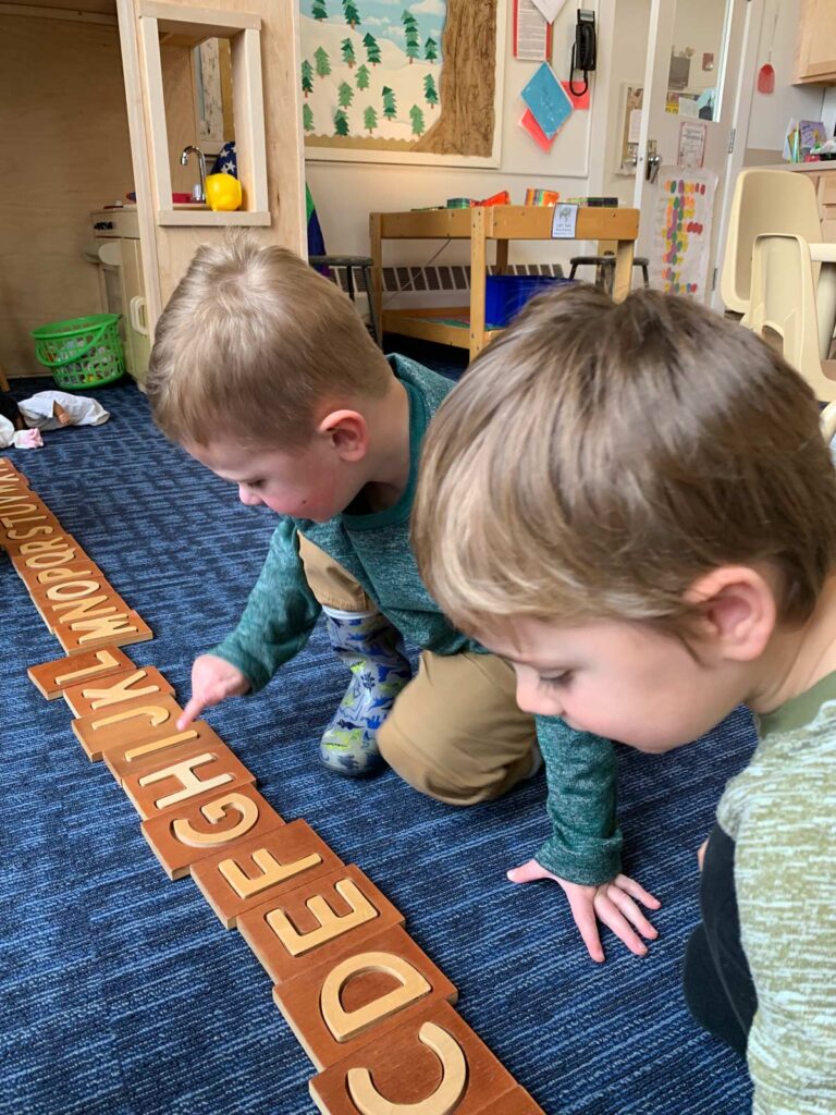 Boys playing with wooden alphabet blocks