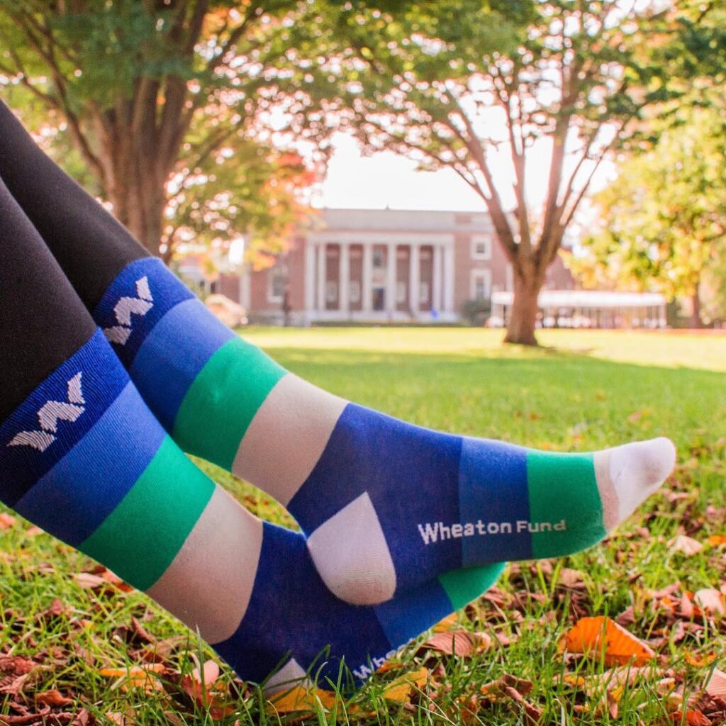 Student wearing colorful Wheaton Fund socks with Wheaton logo
