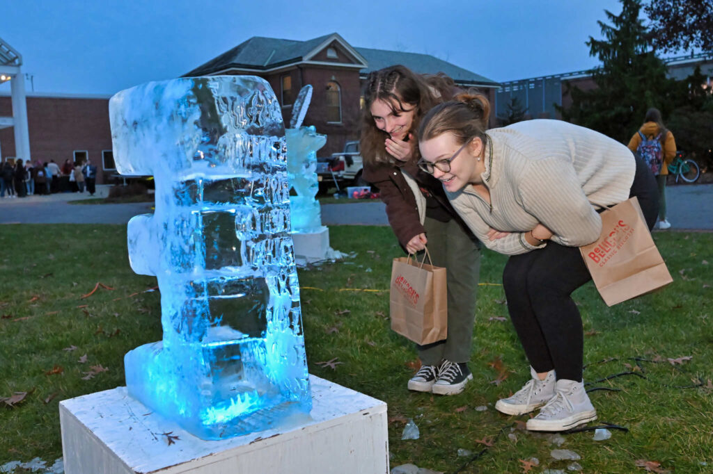 Students viewing illuminated ice sculpture at Winterfest 2023