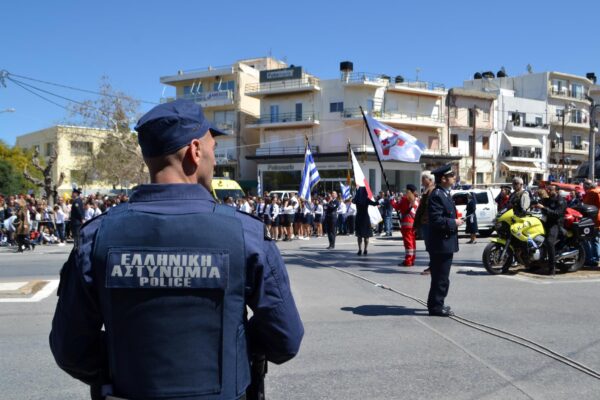 A greek police officer standing at an outdoor celebration.