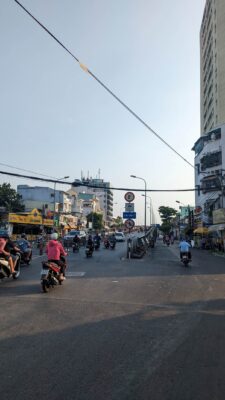 A city street with people riding motorbikes.