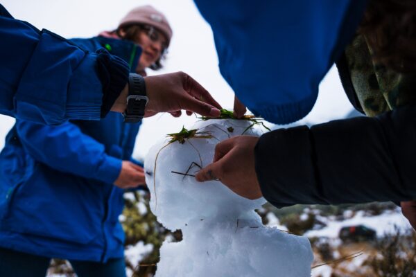 Students building a snowman together.