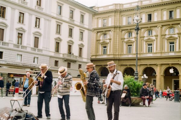 4 men on a street playing instruments.