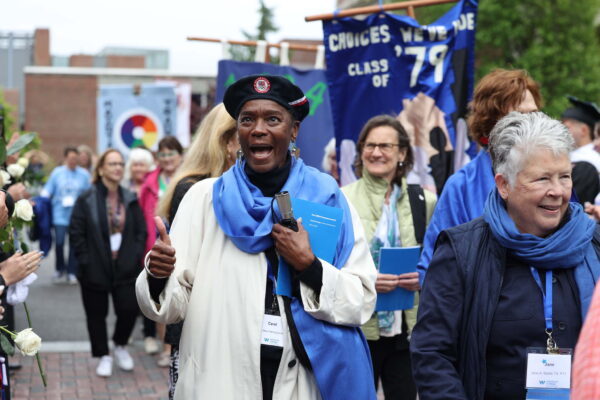 An excited alum walks in the alumni procession