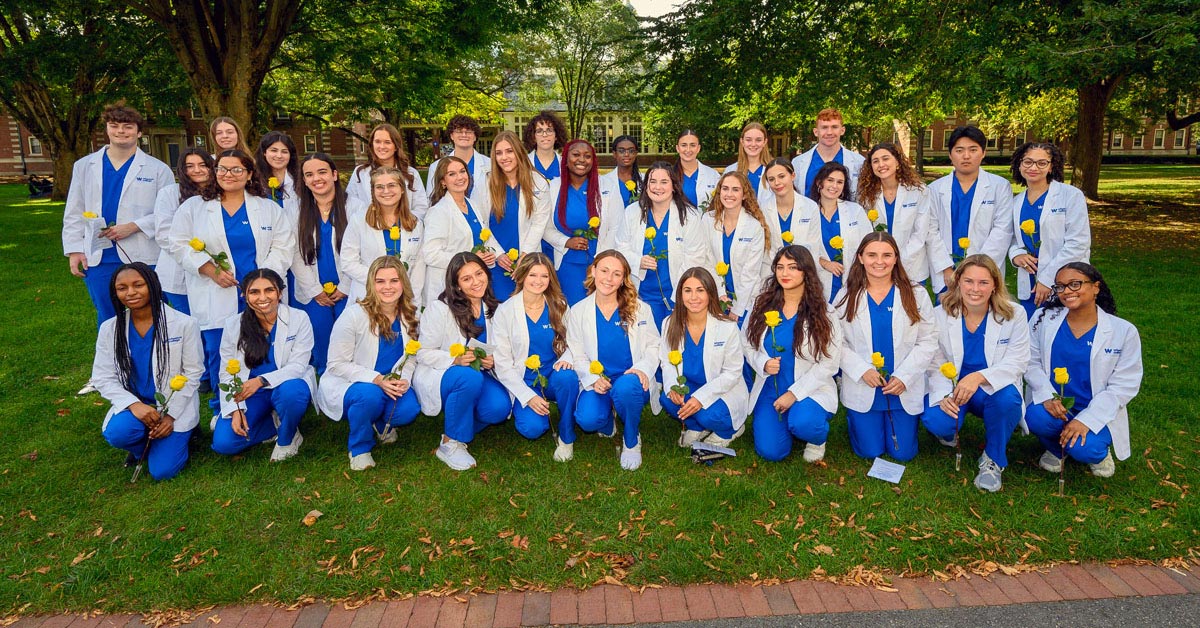 Wheaton College's first class of nursing students wearing their newly earned white coats.