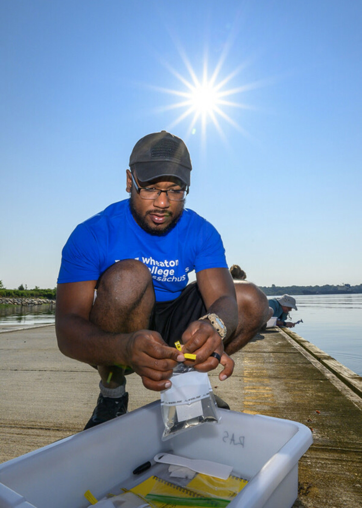 Andrew Davinack puts an aquatic sample in a plastic bag.