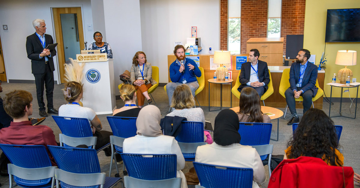Panelists speak in front of an audience.
