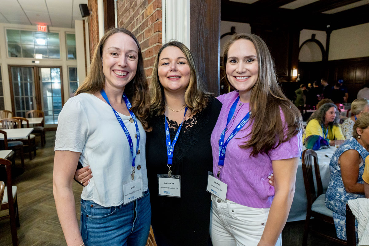Three smiling female Alumni at a reunion