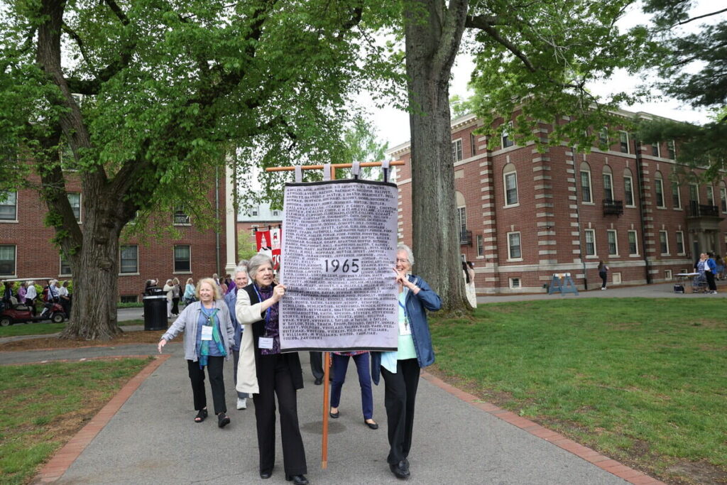 A group of women holding a banner that reads 1965