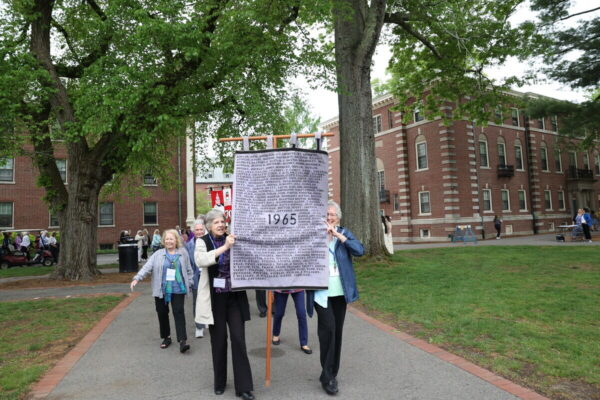 A group of women holding a banner that reads 1965