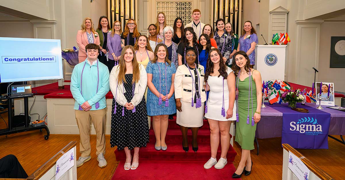 Nursing students inducted into the honor society pose for a photo with faculty. 