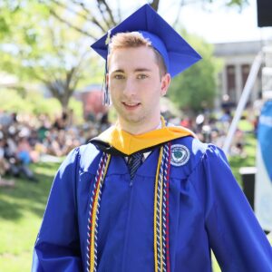 Liam Daley dressed in Wheaton blue cap and gown after receiving his diploma.